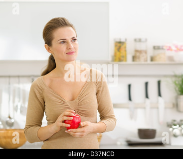 Portrait of young woman with apple en cuisine moderne Banque D'Images