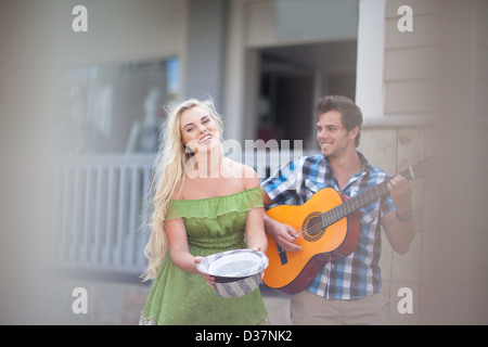 Couple playing music on street Banque D'Images