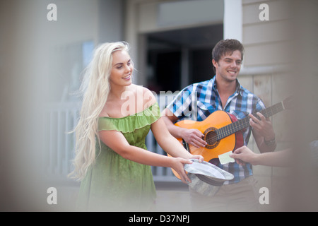 Couple playing music on street Banque D'Images