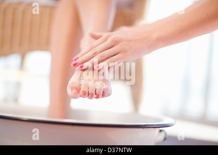 Femme gommage sel sur pieds Banque D'Images