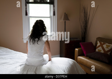 Femme assise sur le bord du lit Banque D'Images