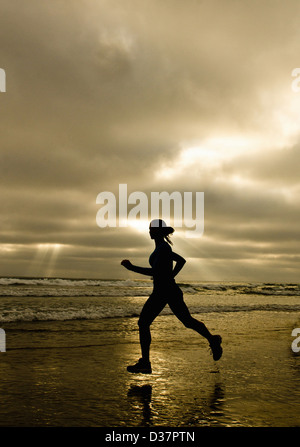 Woman running on beach Banque D'Images