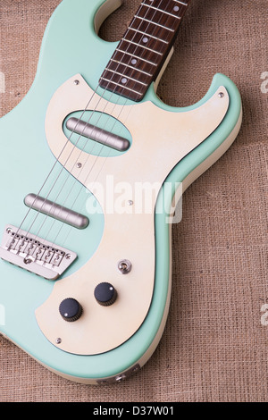 Danelectro baby blue guitare électrique sur un sac en toile de jute avec un éclairage naturel. Banque D'Images