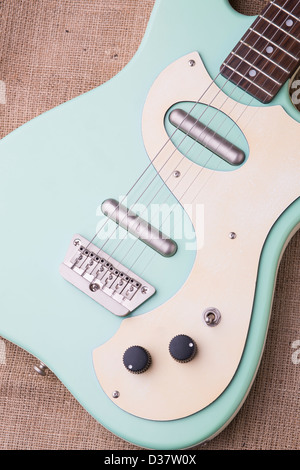 Danelectro baby blue guitare électrique sur un sac en toile de jute avec un éclairage naturel. Banque D'Images