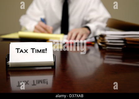 Vérificateur d'impôt IRS man sitting at desk with business card Banque D'Images