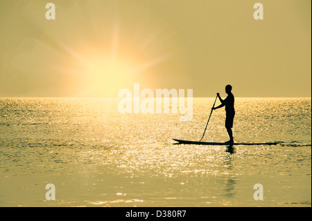 USA, North Carolina, Nags Head, Man Standing on paddle board au coucher du soleil Banque D'Images