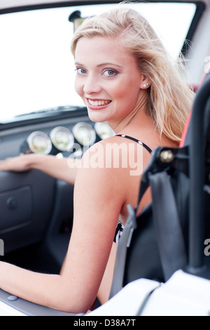 Smiling woman sitting in jeep Banque D'Images