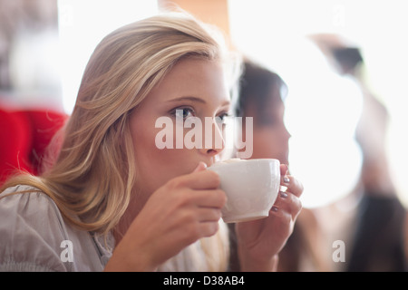 Woman drinking coffee in cafe Banque D'Images