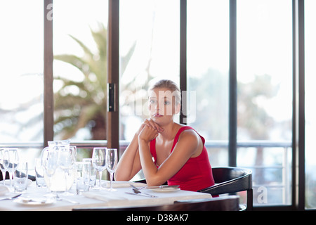 Femme assise à la table de restaurant Banque D'Images