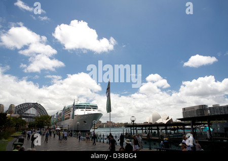Un grand paquebot amarré dans le port de Sydney en Australie, avec une vue lointaine de la Sydney Harbour Bridge et Sydney Opera House à l'arrière-plan. Banque D'Images