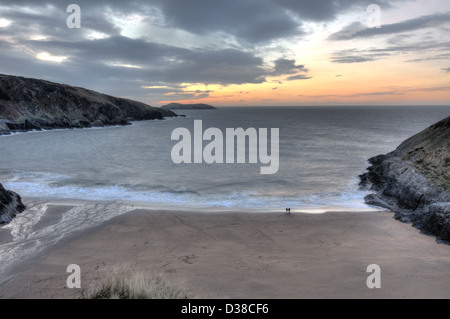 Couple au coucher du soleil sur la plage avec l'Île Mwnt Cardigan Bay et en arrière-plan Banque D'Images