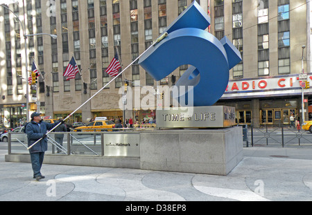 Dans midtown Manhattan nettoie le travailleur à l'extérieur de la sculpture Time & Life Building sur l'Avenue of the Americas & West 50th Street Banque D'Images