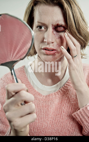 L'examen de son visage meurtri Femme Banque D'Images