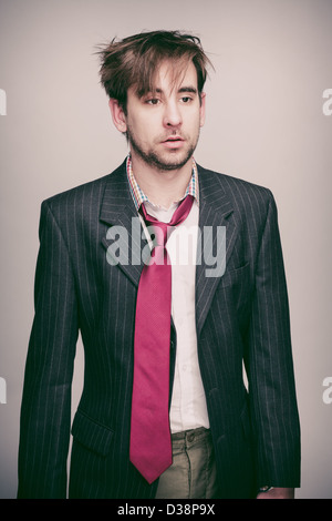 Businessman dans son 20s portant pinstripe veste de costume, chemise blanche, cravate rouge, l'air stupéfait. Banque D'Images