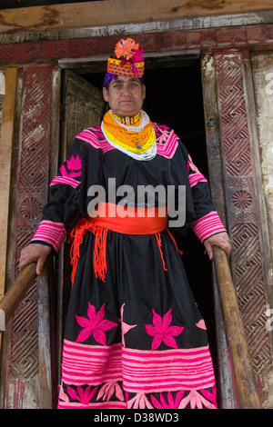 Femme formidable à la Kalash en costume traditionnel sur les marches d'une maison au village, Bumburet Krakl Valley, Chitral, Khyber-Pakhtunkhwa, Pakistan Banque D'Images