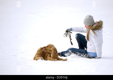 Fille qui marche en hiver avec spaniel Banque D'Images