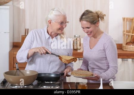 Mère et fille la cuisson des crêpes Banque D'Images