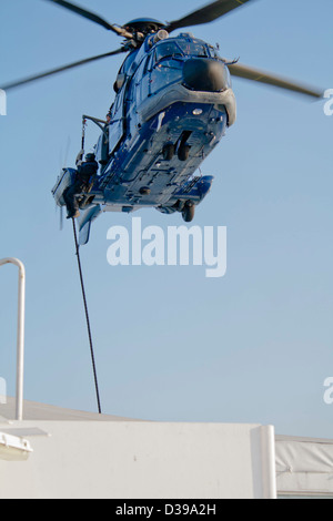 Forces spéciales (SWAT) Agent descend sur corde à partir d'un hélicoptère de police (un fait français AS 332 Super Puma L1 Eurocopter) Banque D'Images