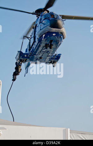 Forces spéciales (SWAT) Agent descend sur corde à partir d'un hélicoptère de police (un fait français AS 332 Super Puma L1 Eurocopter) Banque D'Images