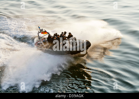 Une des forces spéciales SWAT -police- coque rigide gonflable (type zodiac) voile frappant le service d'un navire et la création d'un lot de pulvérisation. Banque D'Images