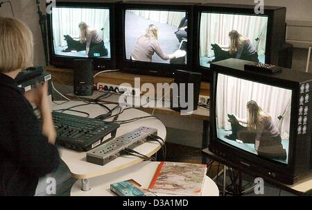 (Afp) - Un employé de l'Hôpital universitaire de psychiatrie de l'enfant à Leipzig, en Allemagne, l'enregistrement vidéo est une thérapie leçon avec un chien et une fille patiente, 5 mars 2002. Le chien thérapie est unique en Europe et seulement pratiqué à Leipzig. Des chiens spécialement dressés pour les enfants stimulent les émotions et hôtel Banque D'Images