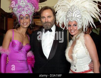 (Afp) - L'acteur italien Franco Nero est accompagné dans la salle de bal par deux hôtesses au 20e Bal de l'Opéra de Francfort, 23 février 2002. Néron était un des invités internationaux. Banque D'Images