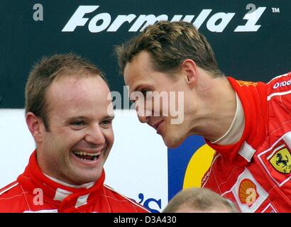 (Afp) - L'Allemand pilote de Formule 1 Michael Schumacher (R) s'entretient avec son coéquipier Rubens Barrichello brésilienne après le British Grand Prix de Formule 1 à Silverstone, 7 juillet 2002. Banque D'Images