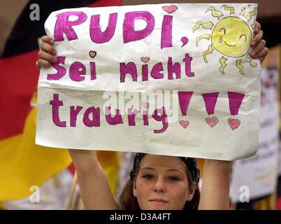 (Afp) - une jeune fille nous tend un banner reading 'Rudi sei nicht traurig ! ! !' (Rudi, ne sois pas triste !) alors que des milliers de supporters de football attendent l'arrivée de l'équipe nationale allemande pour une réception à l'Hôtel de Ville Roemer Square à Francfort, 1 juillet 2002. L'Allemagne a gagné la deuxième place dans la coupe du monde après Banque D'Images