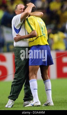 (Afp) - L'entraîneur brésilien Luis Felipe Scolari (L) hugs Rivaldo après avoir remporté la demi-finale de la Coupe du Monde à Saitama, Japon, le 26 juin 2002. Le match s'est terminé 1:0 pour le Brésil, qui est qualifié pour la 7ème fois pour la finale de la Coupe du monde. Banque D'Images