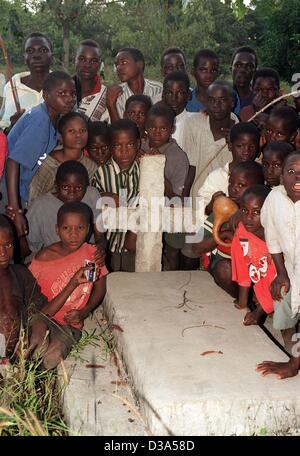 (Afp) - Les orphelins se retrouvent autour d'une tombe dans le village de Kalambo, le nord du Malawi, 13 juin 2001. L'UNICEF appuie des projets de garde d'enfants dans le village qui a un pourcentage élevé de personnes infectées par le SIDA, dont les bébés qui ont acquis l'infection dans l'utérus. De nombreux enfants ont perdu leurs deux parents et ca Banque D'Images