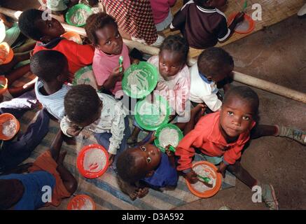 (Afp) - Les enfants prennent leur repas assis à même le sol, dans l'orphelin garderie dans Josamu, le sud du Malawi, 12 juin 2001. L'Organisation des Nations Unies pour l'enfance (UNICEF) appuie le centre, où 60 enfants sont pris en charge. La plupart d'entre eux ont perdu leurs deux parents au virus du sida et beaucoup d'entre eux porter Banque D'Images
