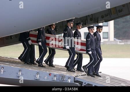 (Afp) - Une garde d'honneur de l'armée américaine porte le cercueil, recouvert du drapeau, contenant les restes d'un soldat américain au large d'un avion à la base aérienne de Ramstein, en Allemagne, 5 mars 2002. Le cercueil a été transporté à Dover/New York dans la soirée. Au total, neuf soldats, dont sept Américains, avaient été tués lors d'une mis Banque D'Images