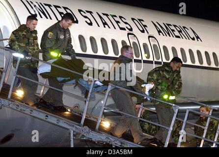 (Afp) - Des soldats américains portent un camarade blessé sur un avion de l'Armée de l'air à la base aérienne US à Ramstein, en Allemagne, le 6 mars 2002. Au total, dix soldats, qui ont été blessés dans des affrontements avec des combattants talibans et d'Al-Qaida en Afghanistan, de l'Est ont été transportés à l'hôpital de l'armée américaine de Landstuhl, en Allemagne. Banque D'Images