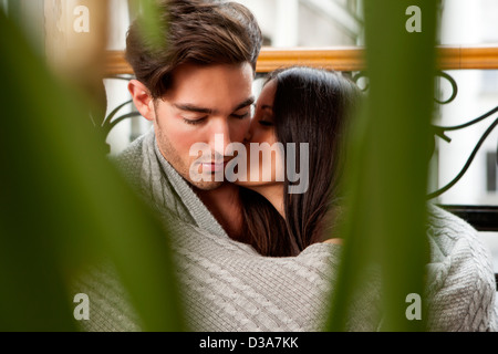 Kissing couple wrapped in blanket Banque D'Images