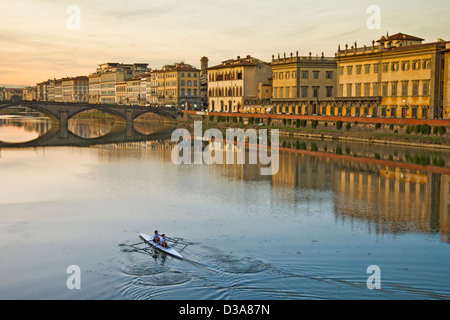 Deux rameurs féminins sur l'Arno, dans le centre de Florence, l'Italie, l'aviron vers le Ponte alla Carraia et l'Lugarno Corsini. Banque D'Images