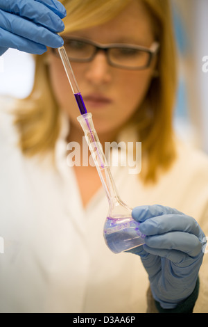 Young female scientist in laboratory de l'université travaille avec des liquides colorés Banque D'Images