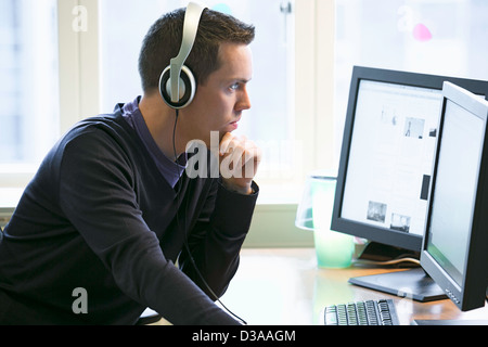 L'homme utilisant des ordinateurs au bureau Banque D'Images