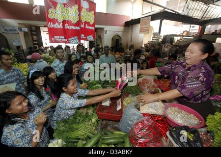 14 février 2013 - Solo, Central Java, Indonésie - 14 février 2013 - Solo, Central Java, Indonésie - Les élèves ont célébré le jour de Valentine avec fleurs et chocolats distribués aux traders le 14 février 2013 à Pasar Gede, Solo, le centre de Java, en Indonésie. Les étudiants ont aussi chanté une chanson en marchant autour du marché pour divertir les marchands. (Crédit Image : © Sijori Images/ZUMAPRESS.com) Banque D'Images