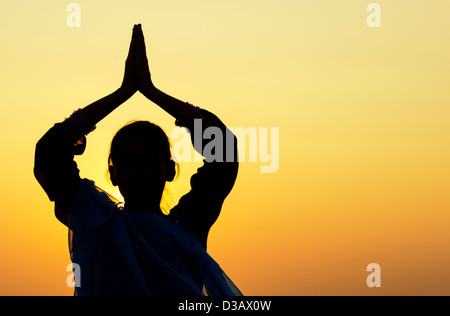 Indian woman praying at sunset portant un voile star. Silhouette. L'Inde Banque D'Images