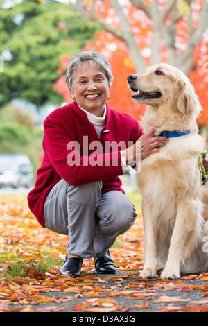Mixed Race woman petting dog Banque D'Images
