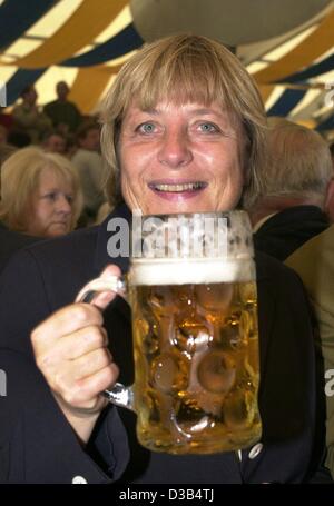 (Afp) - Angela Merkel, présidente de l'Union chrétienne-démocrate CDU, boissons un Stein de bière pendant une fête folklorique à Abensberg, Bavière, 2 septembre 2002. Trois semaines avant les élections générales les politiciens de toutes les parties ont fait des discours électoraux à la fête des tentes. Banque D'Images