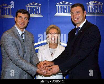 (Afp) - Dans un geste symbolique, l'ambassadeur de l'UNESCO Ute-Henriette Ohoven et les frères de boxe Vladimir (L) et Vitali Klitschko joignent leurs mains au cours d'une conférence de presse à Düsseldorf, 25 septembre 2002. Le projet de l'UNESCO "l'éducation pour les enfants dans le besoin", lancé par Ohoven, commencé un partenaire Banque D'Images