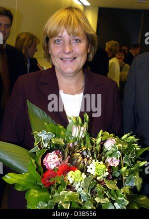 (Afp) - Angela Merkel, présidente de la CDU et nouveau chef de la fraction CDU au Bundestag, est titulaire d'un bouquet de fleurs et sourit aux photographes, Berlin, 24 septembre 2002. 214 députés de la fraction CDU/CSU a voté pour les 48 ans, 18 ont voté 'non', onze voix contre n'étaient pas valides. Ange Banque D'Images