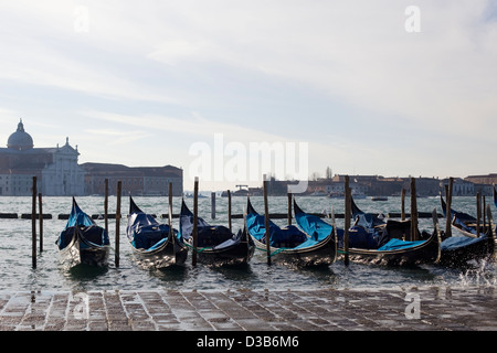 Gondoles stationné à leurs amarres à fond plat traditionnel bateau d'aviron de Venise sur le Grand Canal Venise Italie Banque D'Images
