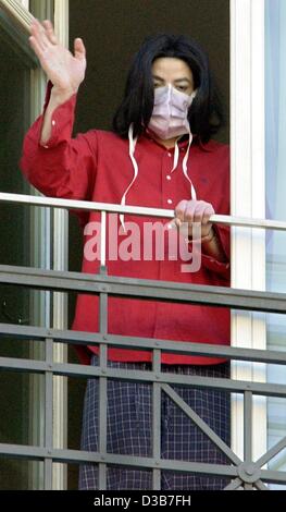 (Afp) - La pop star Michael Jackson porte son masque qu'il brandit à wellwishers depuis le balcon d'une suite dans l'hôtel Adlon à Berlin, le 21 novembre 2002. Jackson est à Berlin pour recevoir un Bambi award divertissement Popstar du siècle" le 21 novembre. Banque D'Images