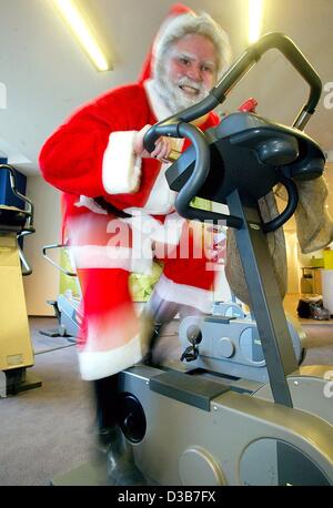 (Afp) - un homme habillé en père Noël fonctionne dans une salle de sport à Berlin, 18 novembre 2002. Santa a besoin pour se mettre en forme pour Noël, comme la livraison de cadeaux peut être travail dur... Banque D'Images