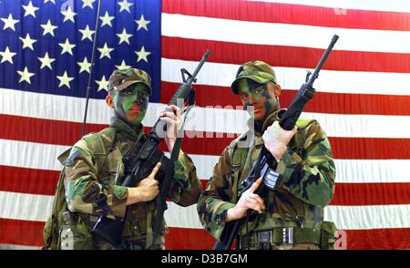 (Afp) - Deux soldats de la 52e Escadre de chasse de l'US Air Force posent avec leurs fusils d'assaut M-16 en face d'un énorme drapeau sur la base aérienne US en Allemagne, Spangdahlem, 25 octobre 2002. C'est la plus grande aile de l'US air force des États-Unis en Europe, qui a déjà participé à des missions au-dessus de l'Iraq et dans la région de bosn Banque D'Images