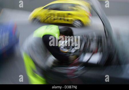 (Afp) - Peter Kaestner du club allemand ADAC auto donne l'assistance routière pour une voiture à Francfort, 12 décembre 2002. En raison d'une vague de froid en Allemagne, l'ADAC (Allgemeiner Deutscher Automobil Club) a déclaré que les appels d'urgence ont plus que doublé. Principale cause de pannes sont la défaillance d'une des batteries Banque D'Images