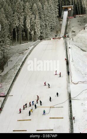 (Afp) - "Treaders" bon le saut en marchant la neige pour la préparer pour l'événement de la Coupe du monde de saut à ski à Titisee-Neustadt dans la Forêt Noire, en Allemagne, le 12 décembre 2002. Quelque 4 000 tonnes de neige ont été spécialement importés de Suisse par camions. Banque D'Images