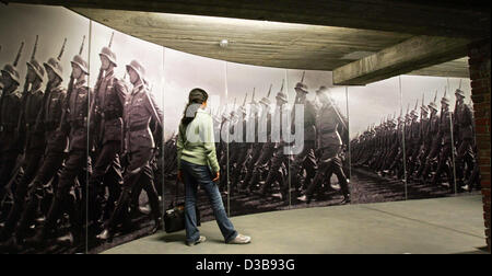 (Afp) - une jeune femme se tient devant une photo qui montre des soldats de la Wehrmacht allemande dans le 'Centre de Documentation' zone de Nuremberg à Nuremberg, Allemagne, 7 juillet 2005. Depuis l'ouverture en novembre 2001, plus d'un demi-million de personnes ont visité le centre. La direction de la documenta Banque D'Images